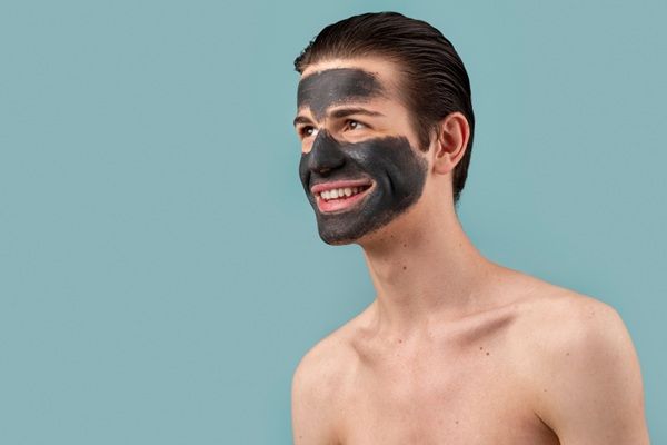 Peeling - Hombre joven aplicándose un peeling facial para suavizar la piel del rostro y eliminar el acné