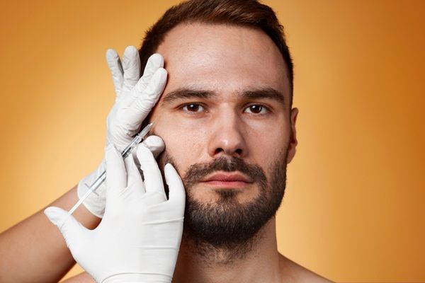 Rellenos dérmicos - Médico estético aplicando un tratamiento con ácido hialurónico Madrid a un hombre para dar volumen al contorno facial