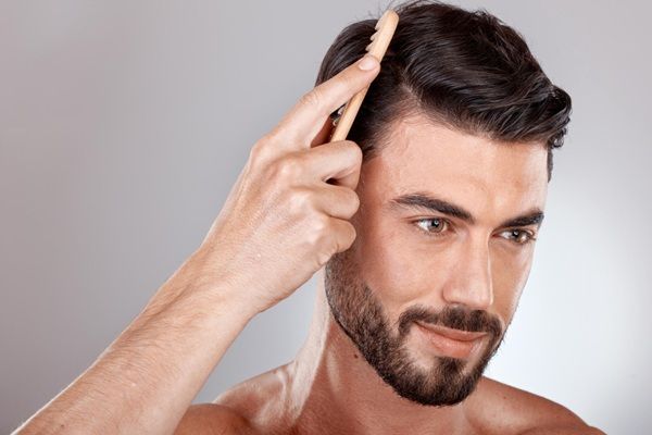 Injerto capilar Madrid - Hombre feliz peinando su cabello abundante luego de un trasplante capilar Madrid en la mejor clínica injerto capilar Madrid