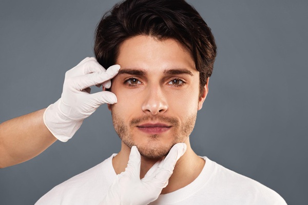 Smart Fillers - Médico estético evaluando el rostro de un hombre para aplicar un tratamiento con rellenos dérmicos inteligentes en Madrid