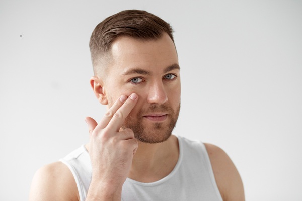 Hombre sin arrugas en los pómulos gracias a los tratamientos estéticos faciales para rejuvenecer la piel del rostro