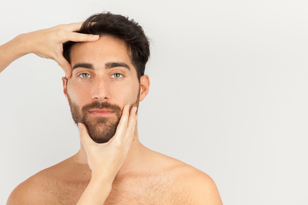 Ácido hialurónico Madrid - Médico estético evaluando el rostro de un hombre para aplicar un tratamiento con ácido hialurónico inyectable