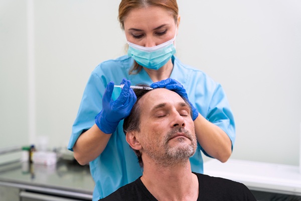 Tratamiento PRP - Médico capilar de la mejor clínica injerto capilar Madrid aplicando un tratamiento de plasma rico en plaquetas a un hombre para estimular el crecimiento del cabello