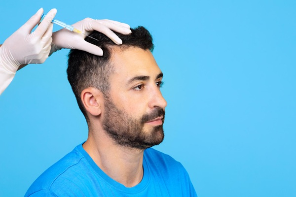 Tricólogo colocando una inyección de plasma rico en plaquetas para fortalecer el cabello de un hombre luego del injerto capilar Madrid