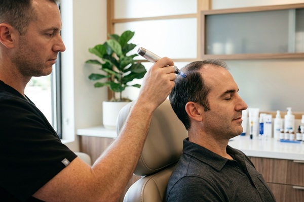 Médico tricólogo realizando un tratamiento de PRP a un hombre para detener la pérdida de cabello