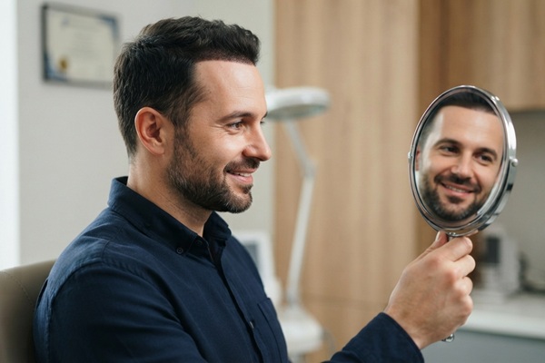 Hombre observando en un espejo los resultados del injerto capilar España